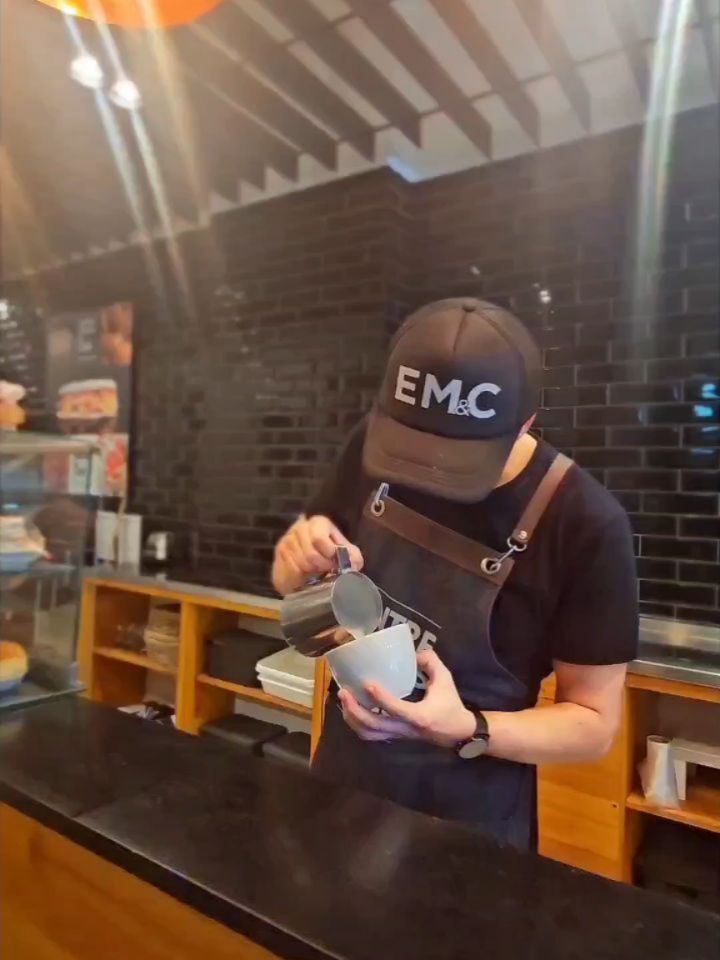 Entre Migas y Café: professional barista preparing coffee